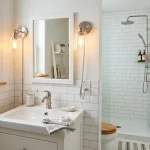 A modernized rental bathroom featuring updated rental bathroom fixtures including a new showerhead and plug-in lighting.